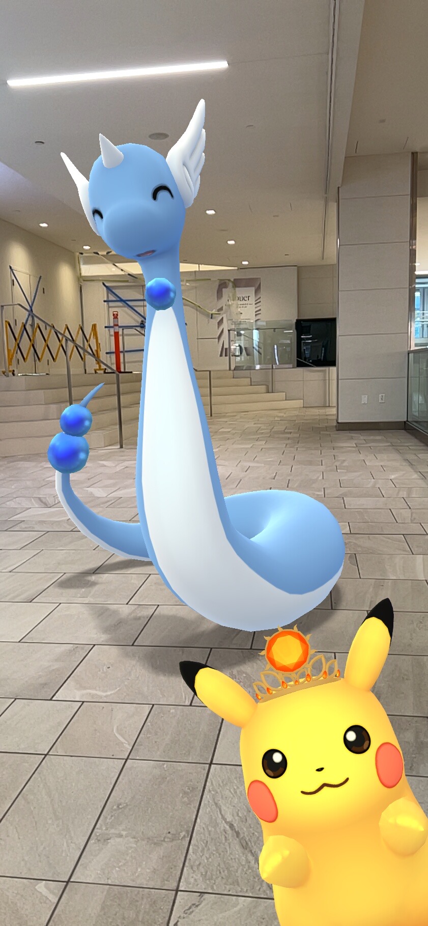 Pokemon Go app in AR view featuring Dragonair and Pikachu. 